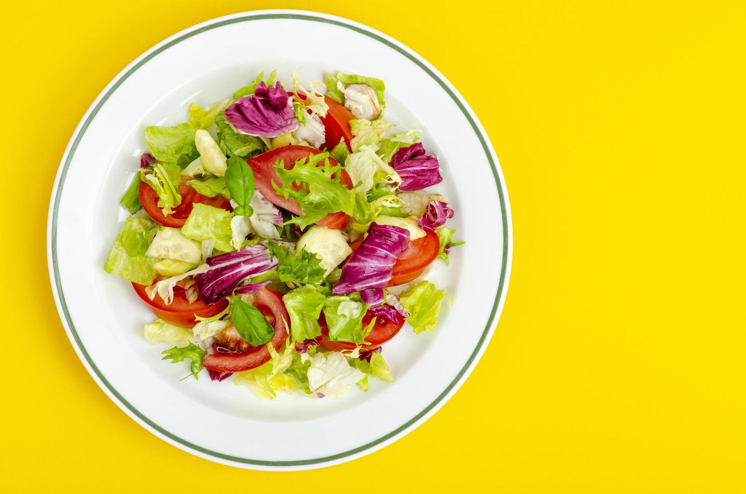 Light dietary vegetarian salad in plate on bright background. Healthy lifestyle concept photo