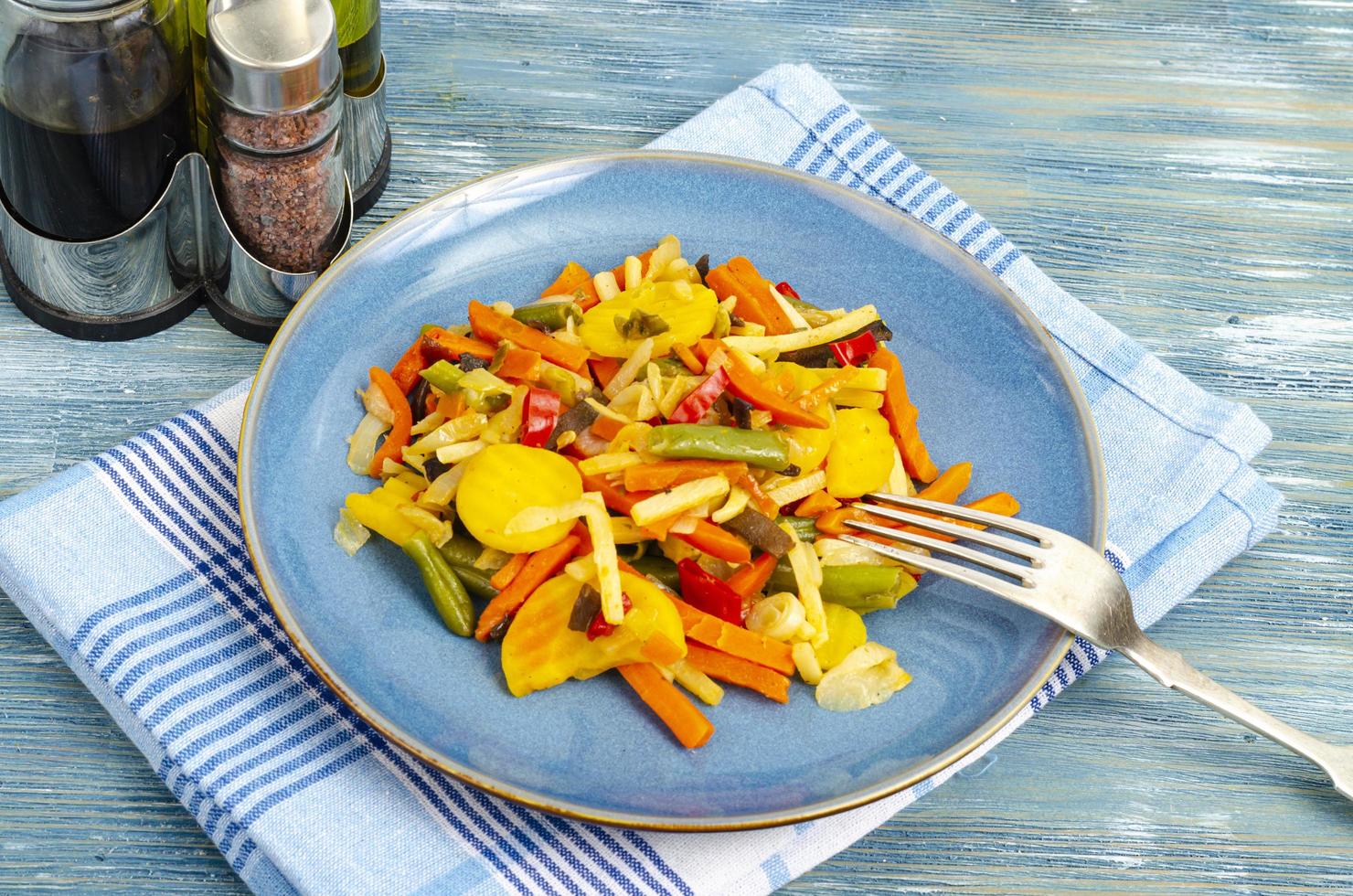 Mix of boiled vegetables in diet food, blue background. photo