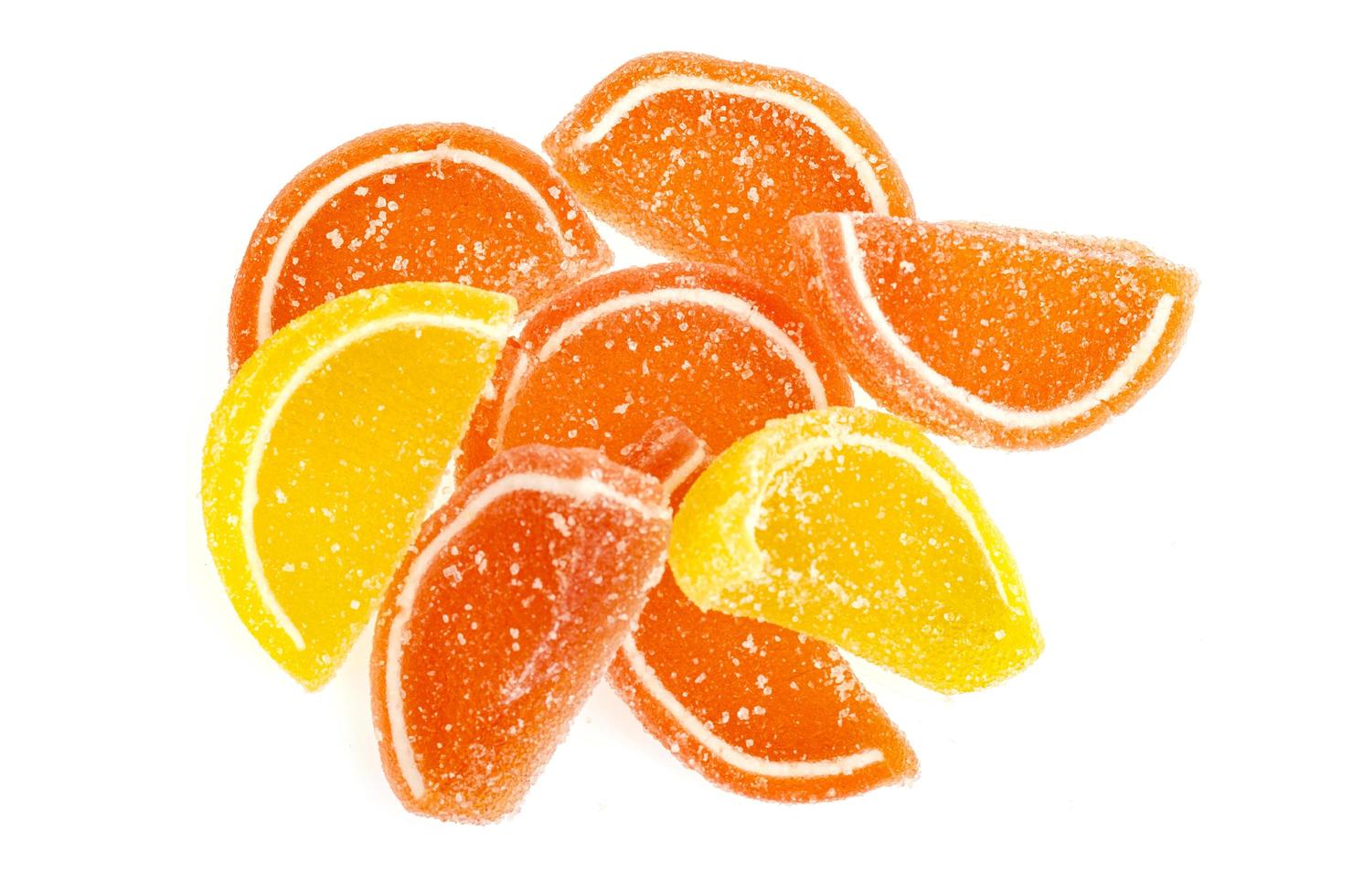 Orange and yellow slices of sweet fruit marmalade in sugar isolated on white background photo