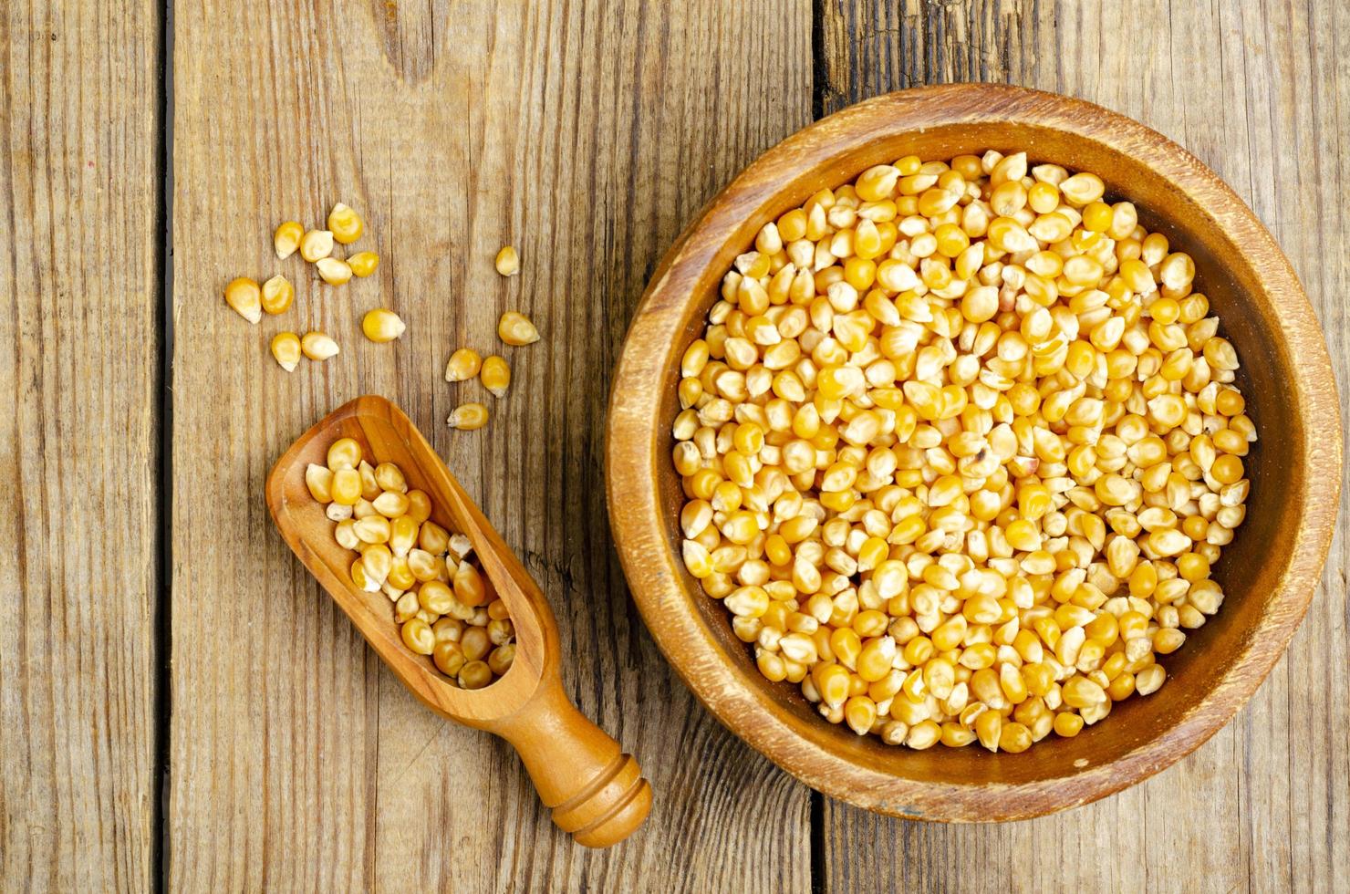 Dry corn grains in bowl for making popcorn. photo