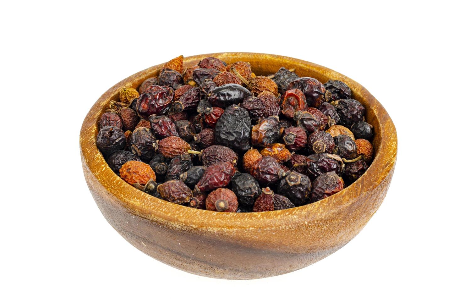 Dried rose hips in wooden bowl, natural vitamin C. photo