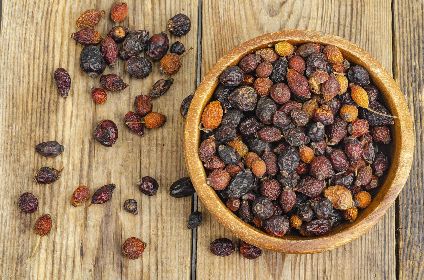 Dried rose hips in wooden bowl, natural vitamin C. photo