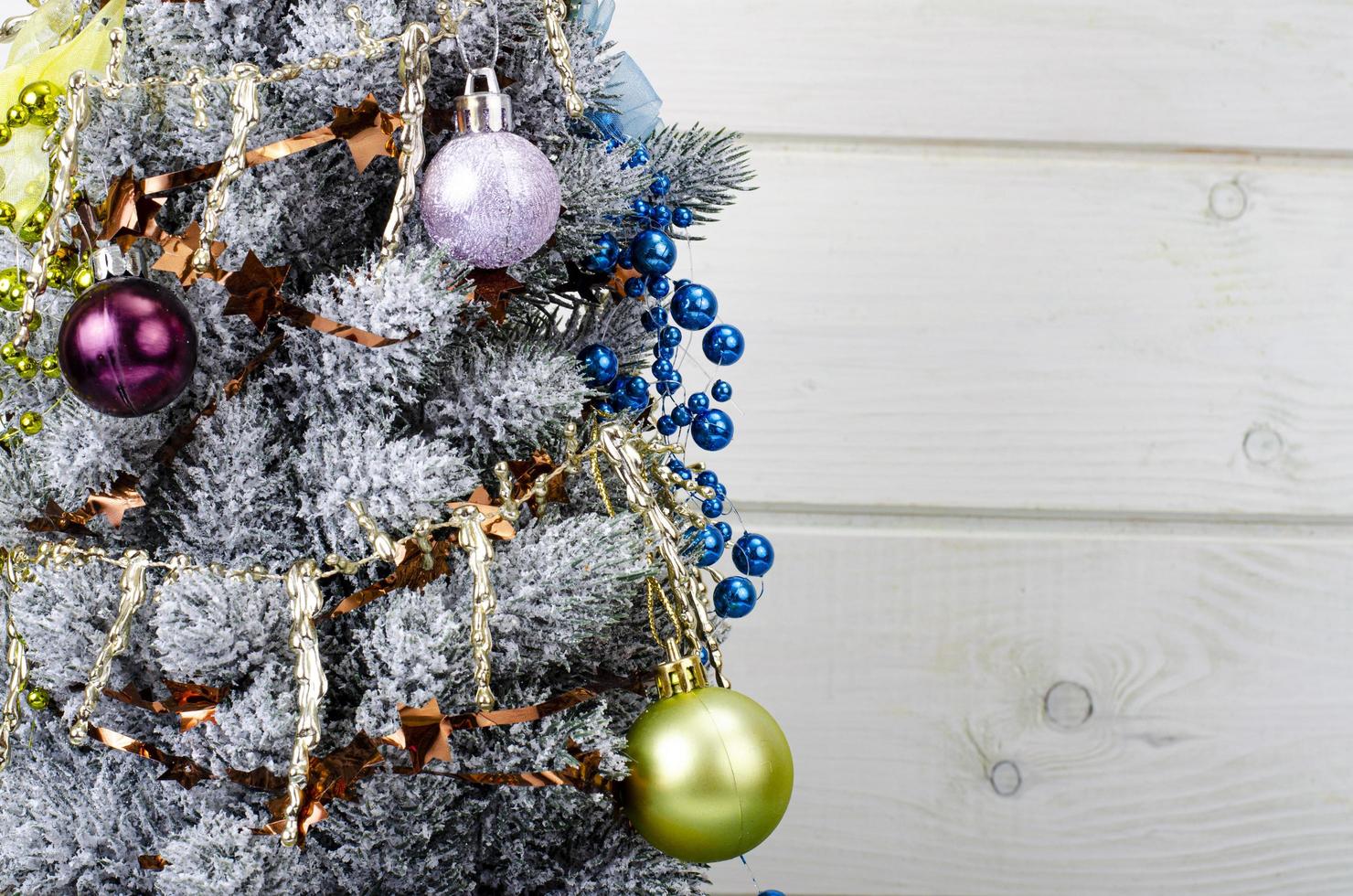 celebramos navidad y año nuevo. pequeño árbol de navidad decorativo decorado con bolas y juguetes. foto de estudio.