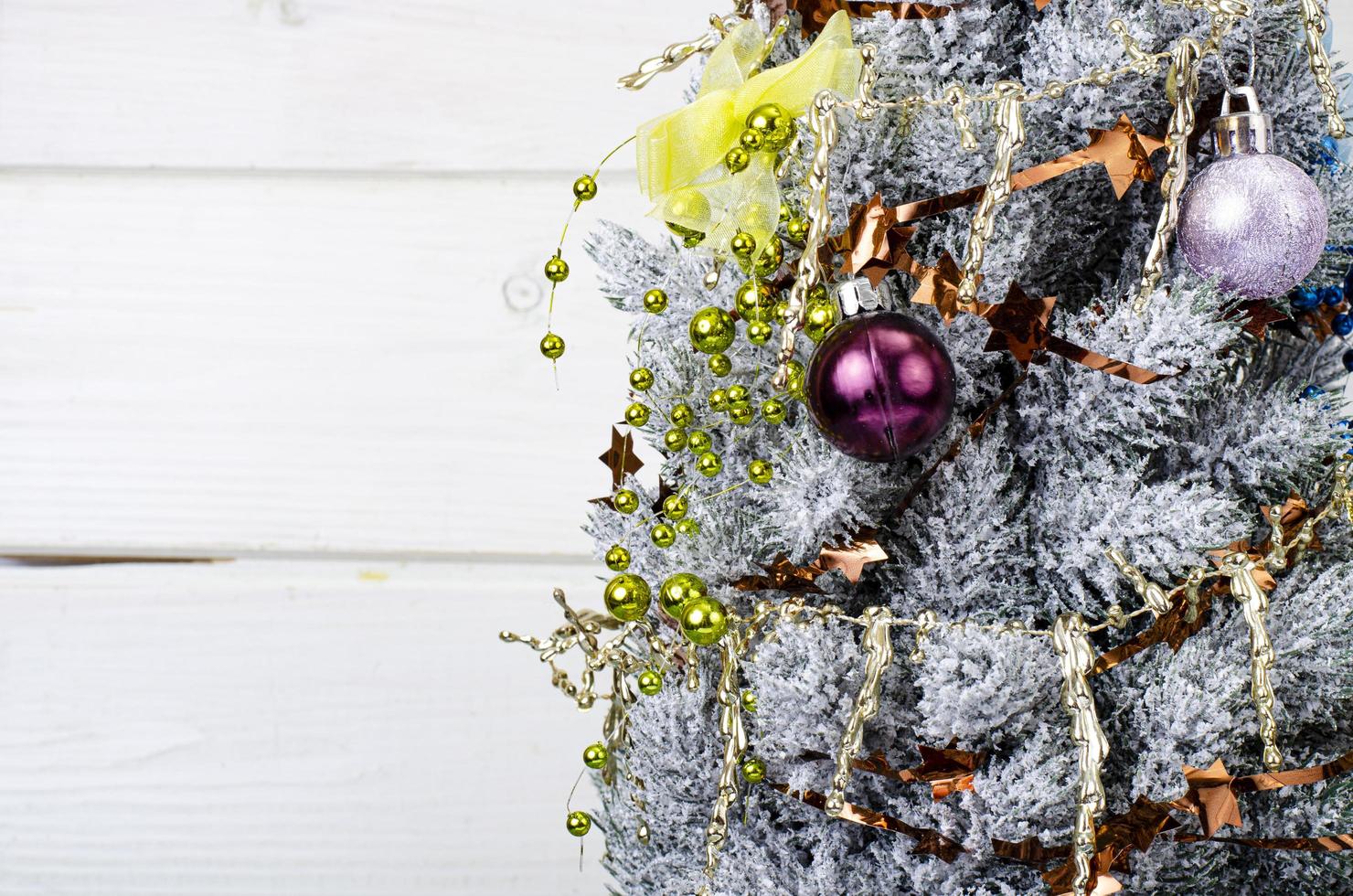 We celebrate Christmas and New Year. Small decorative Christmas tree decorated with balls and toys. Studio Photo. photo
