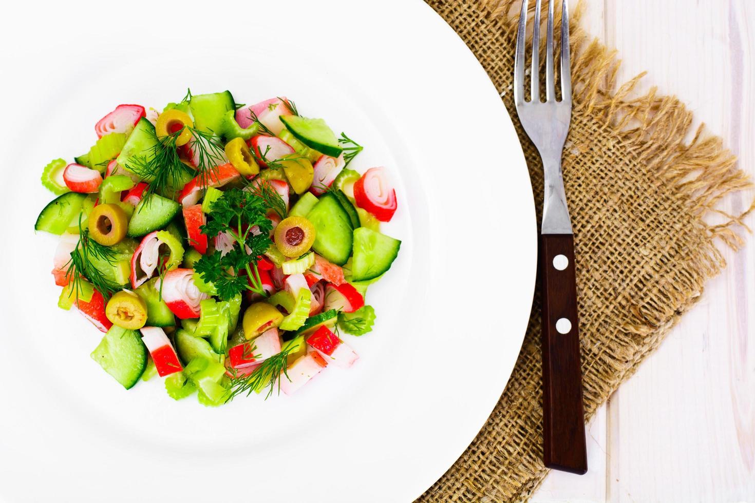 ensalada de apio, palito de cangrejo, pepino, aceitunas verdes y eneldo foto