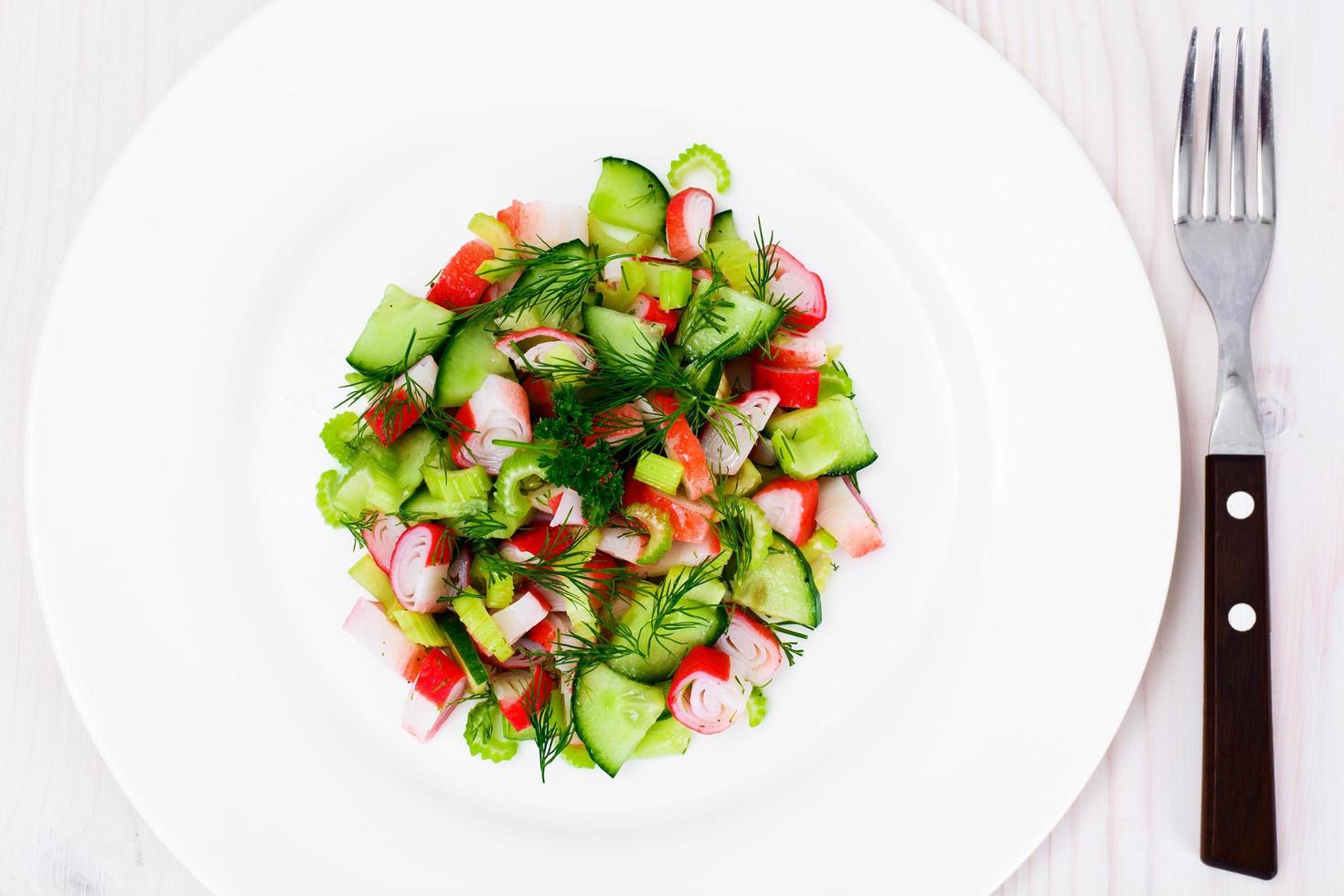 ensalada de apio, palito de cangrejo, pepino, aceitunas verdes y eneldo foto