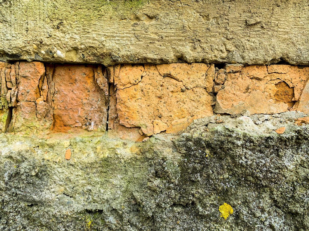 fragmento de un viejo muro de ladrillo enlucido dañado. foto