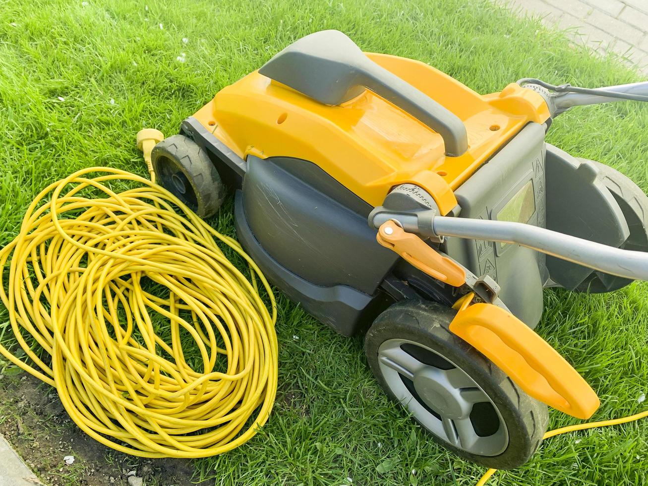 Yellow electric cable on green grass. Photo