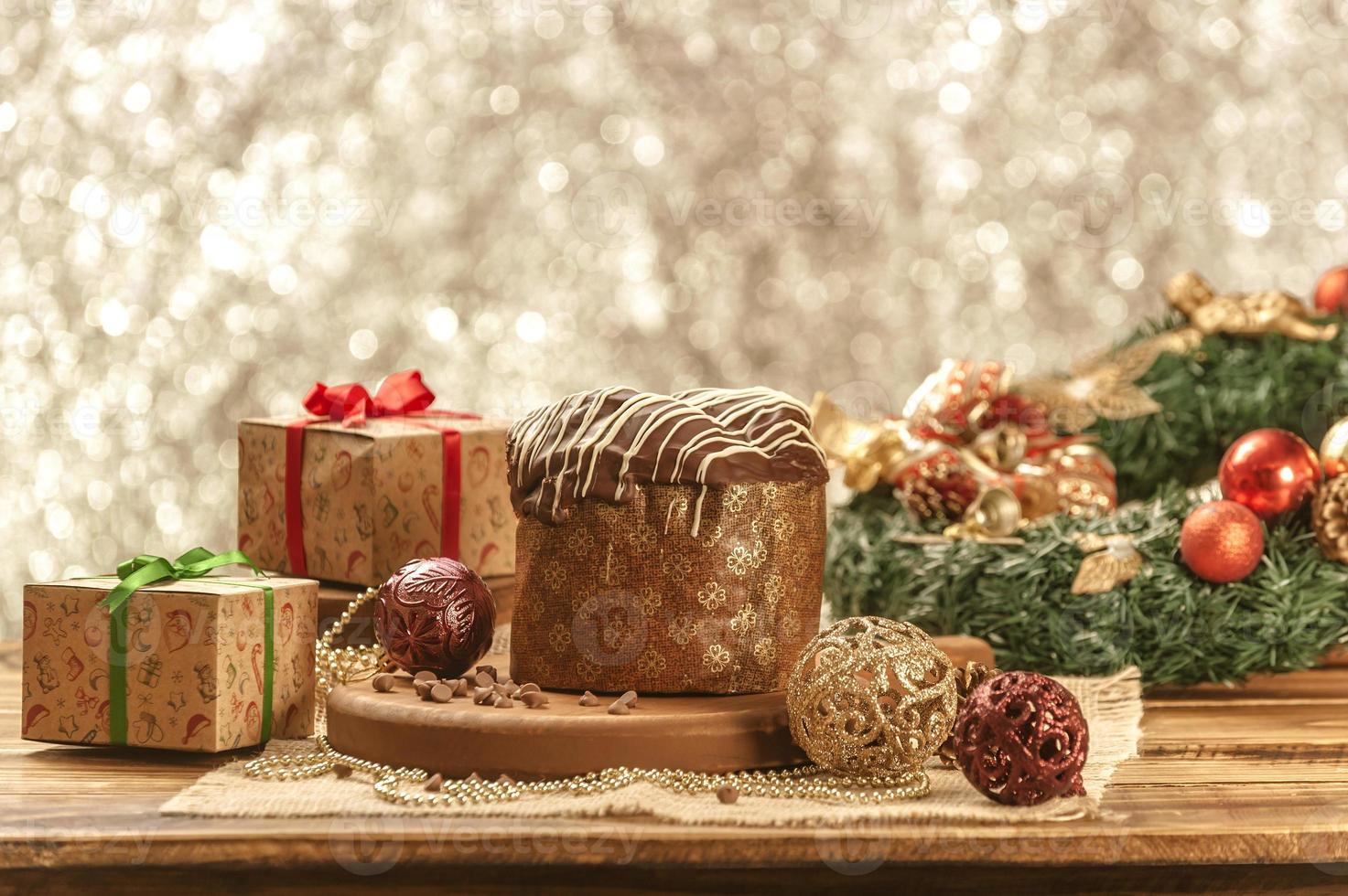 Chocolate panettone  on wooden table with christmas ornaments photo