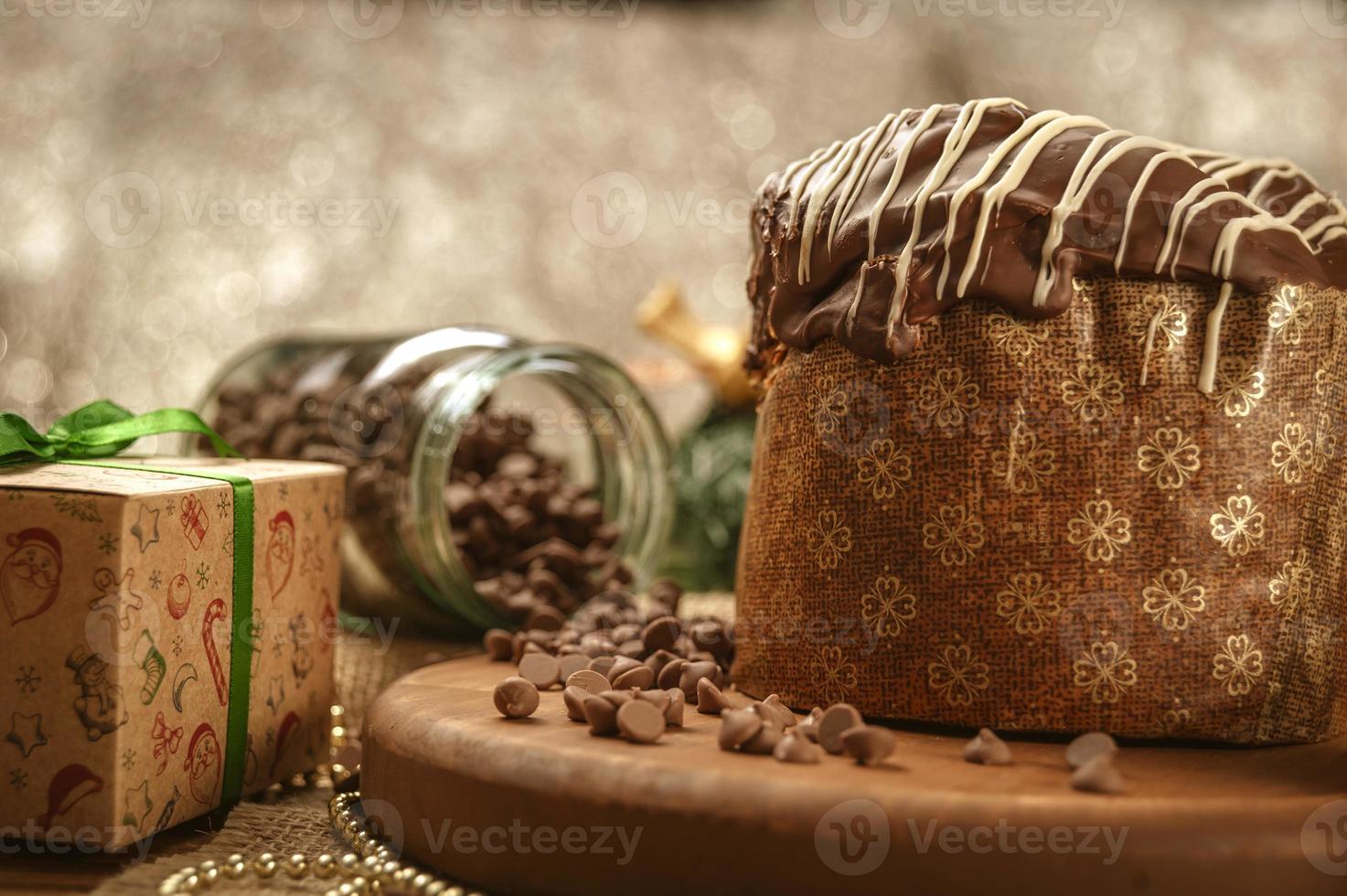 Chocolate panettone  on wooden table with christmas ornaments photo