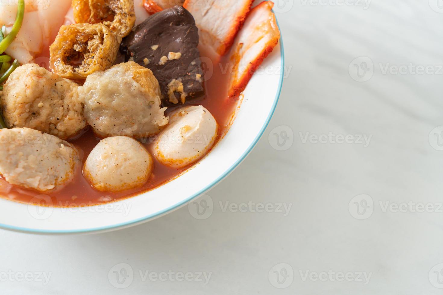 noodles with meatballs in pink soup photo