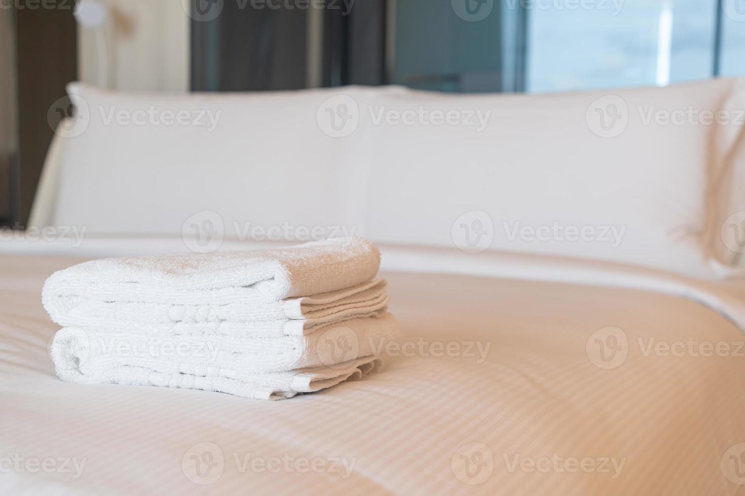 white shower towel on bed photo