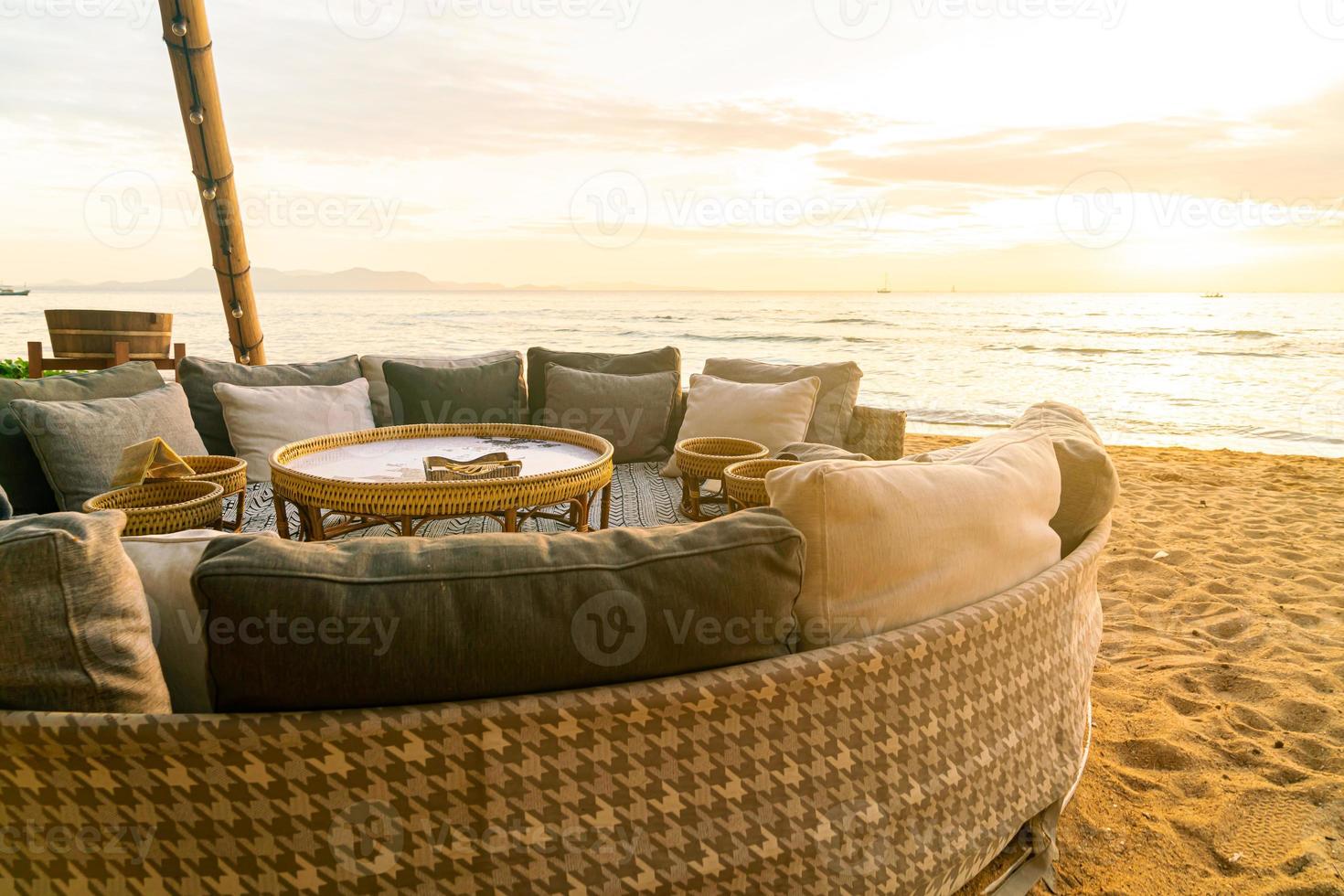 pillows on outdoor patio deck chair on beach with sunset times photo