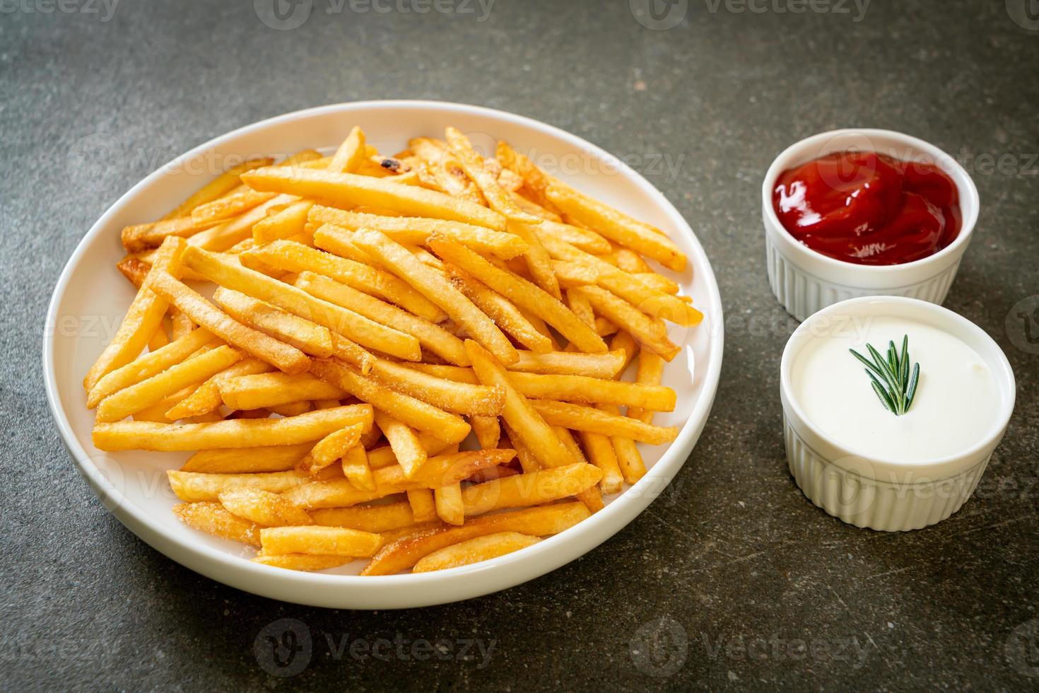 papas fritas con crema agria y salsa de tomate foto