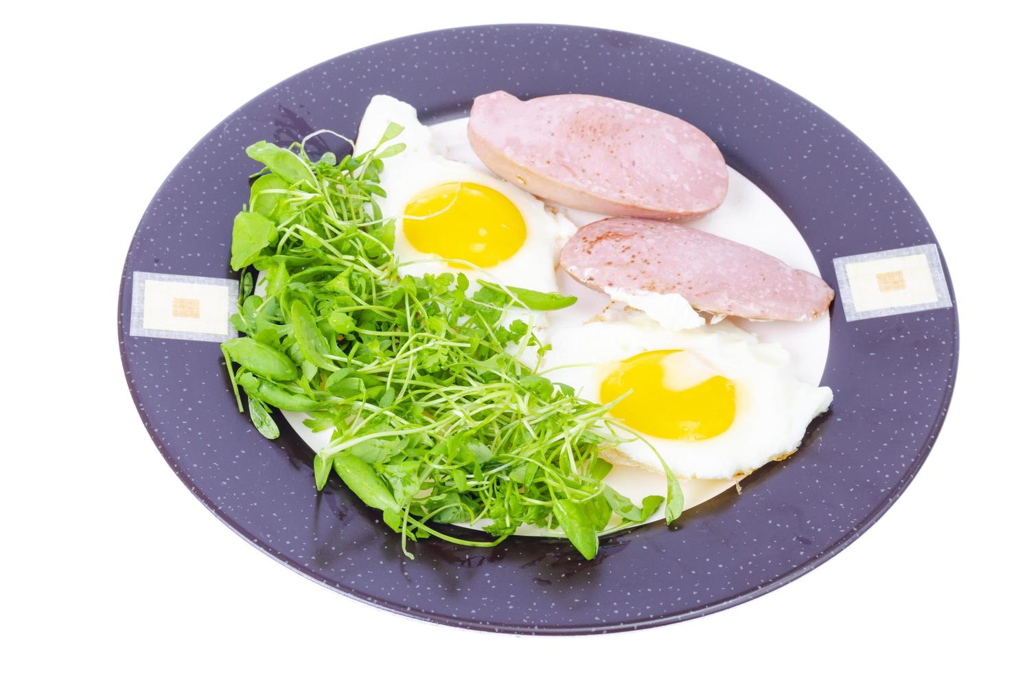 Fried eggs, sausages, fresh green salad, breakfast. photo