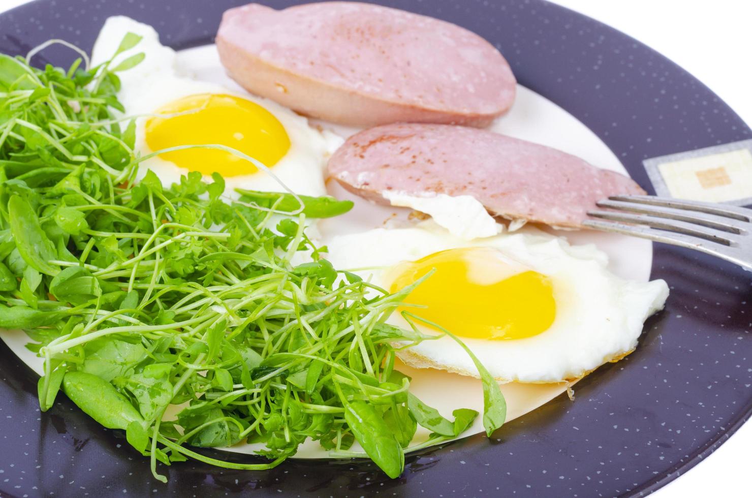 huevos fritos, salchichas, ensalada verde fresca, desayuno. foto