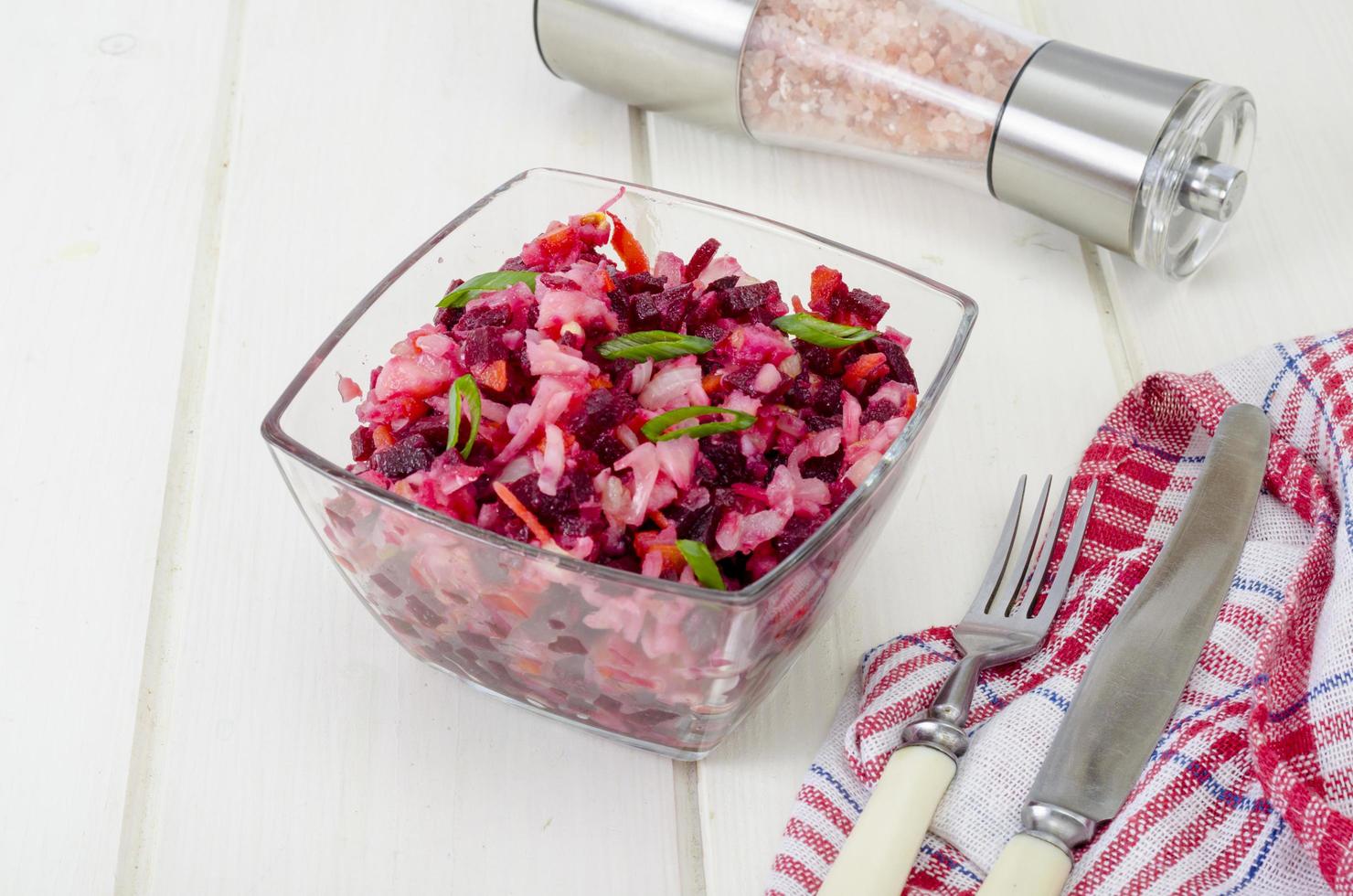 Vegetable salad with beets, spices, onions, garlic on wooden table photo