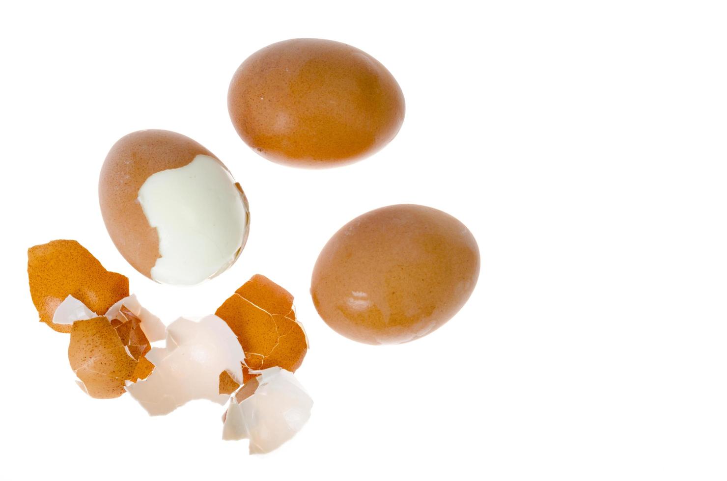 Huevos de gallina cocidos con conchas de colores sobre fondo blanco. foto