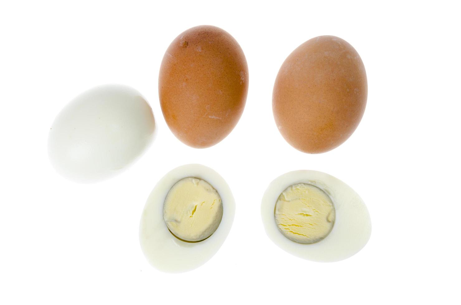 Huevos de gallina cocidos con conchas de colores sobre fondo blanco. foto