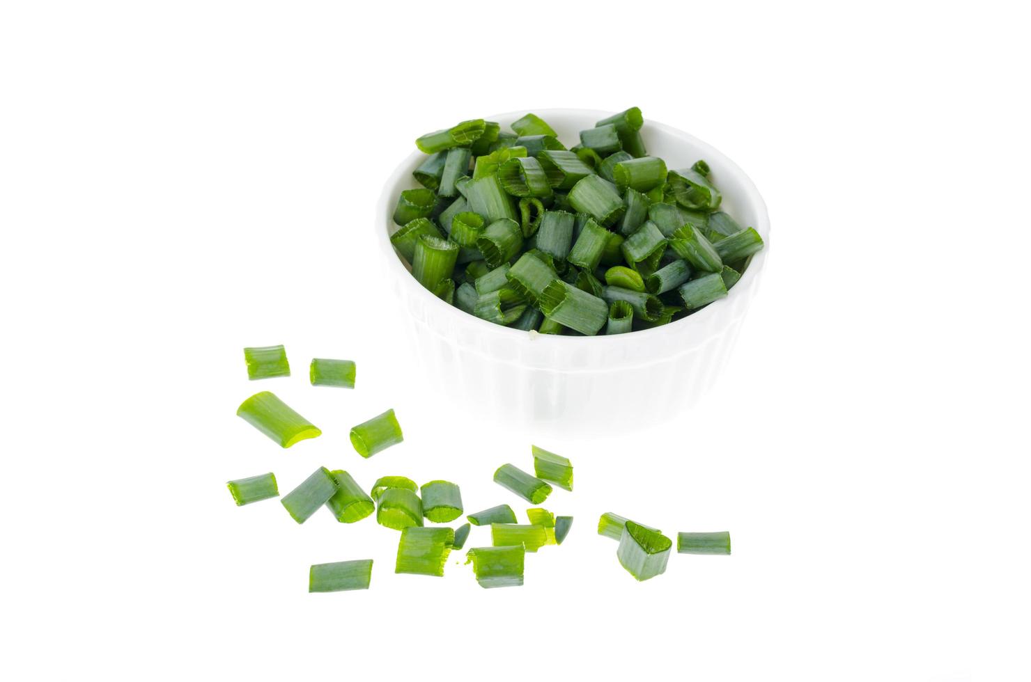 Bowl with slices of chopped green onions for preparing healthy dishes. photo