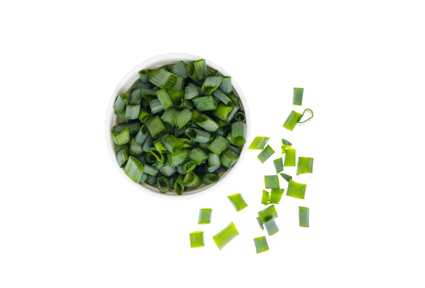 Bowl with slices of chopped green onions for preparing healthy dishes. photo