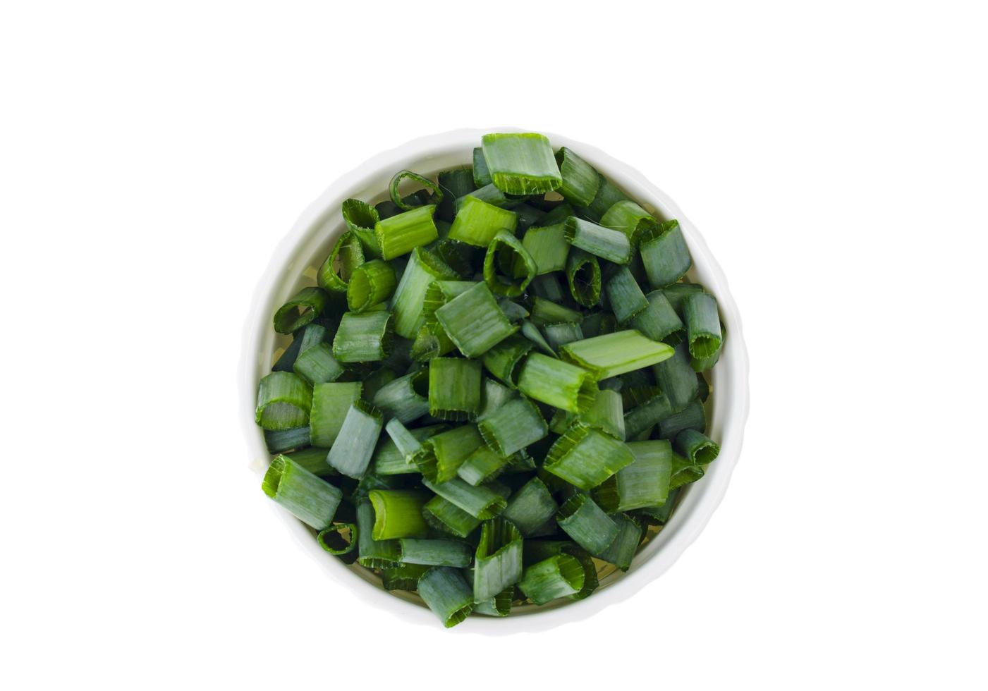 Bowl with slices of chopped green onions for preparing healthy dishes. photo