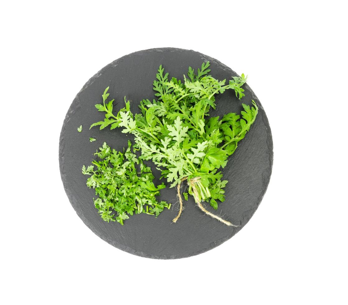 Baunch of edible herbs on black plate. photo