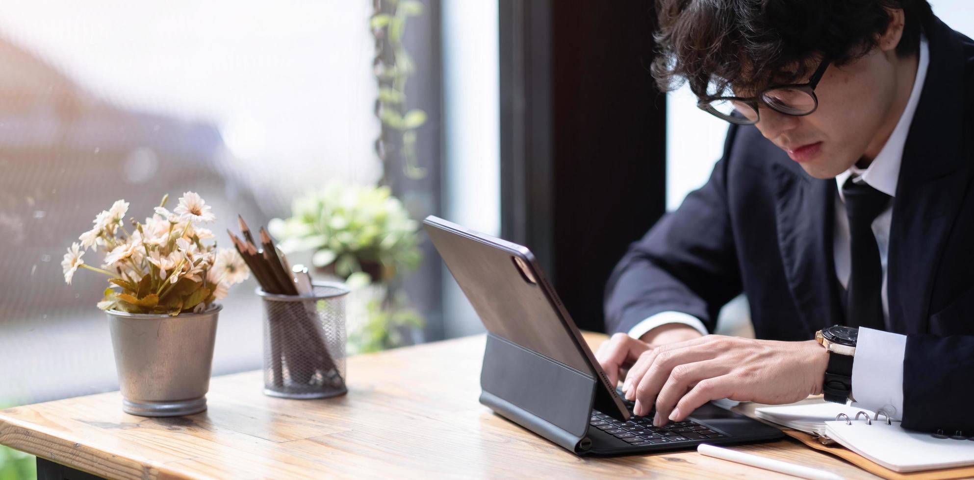 Young businessman working on computer at office. Businessman sitting at office desk working on new project photo