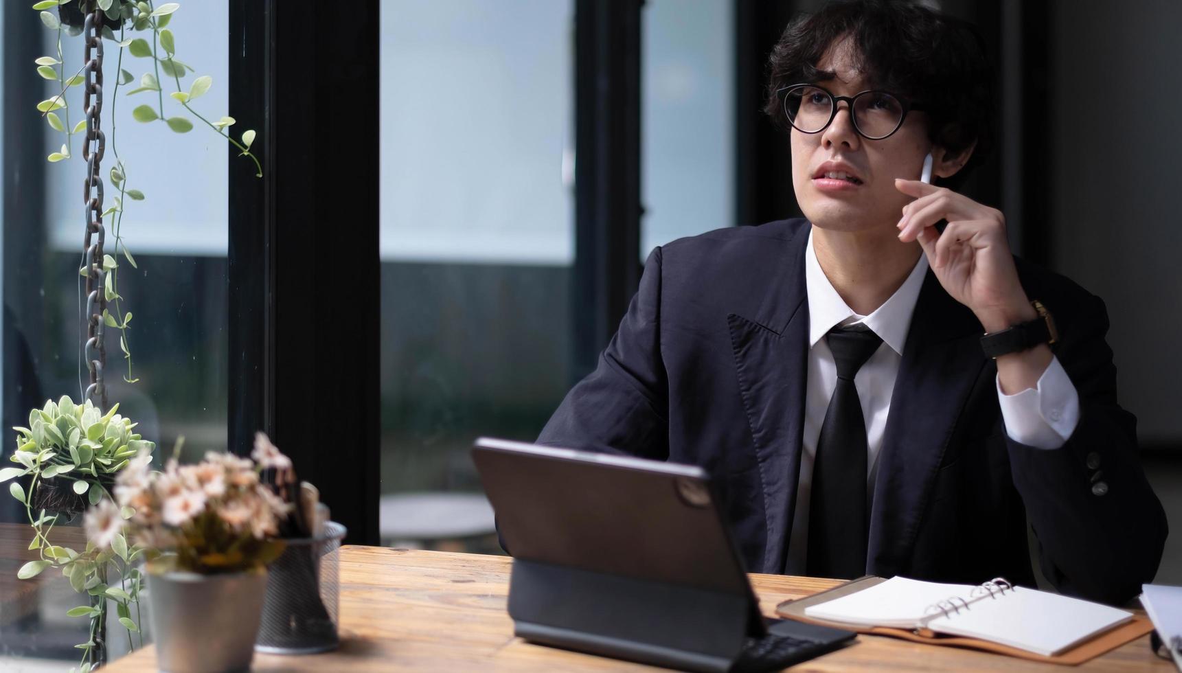 Male business investor looking financial data and investment plan on tablet computer in the office. photo