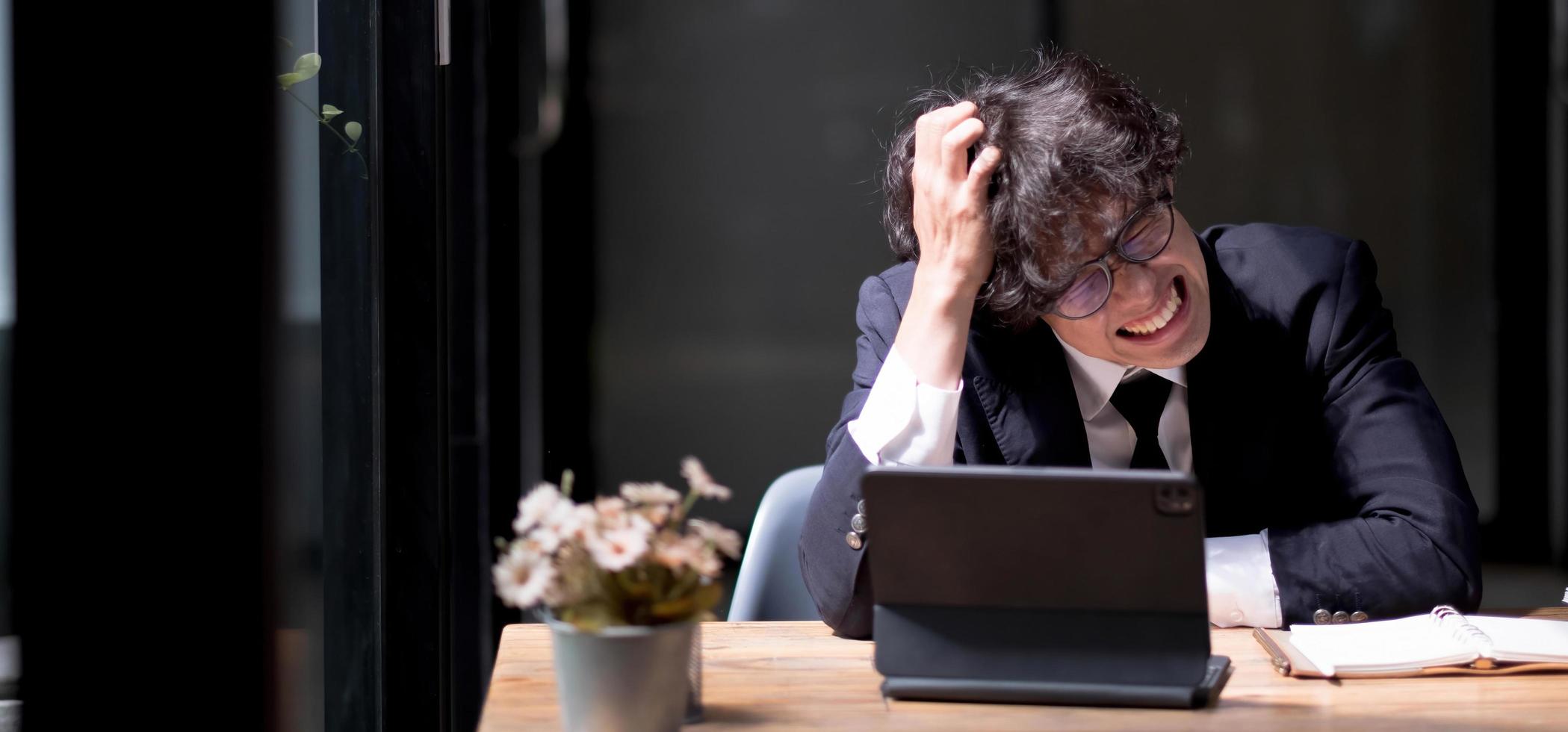 The sad entrepreneur clutched his head. A man in shock on the background of a laptop. This man has received bad news. Ruin of the entrepreneur. Bankruptcy of the company. Trouble. Despair. Crisis photo