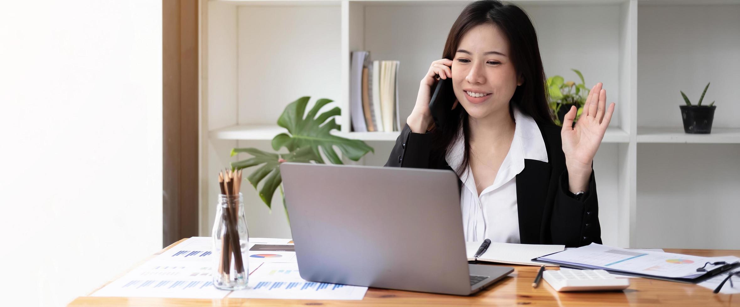 Protrait of Beautiful businesswoman sitting at desk and working with laptop computer. photo