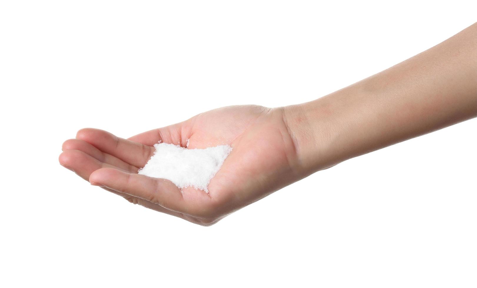 Hand holding sea salt on white background photo