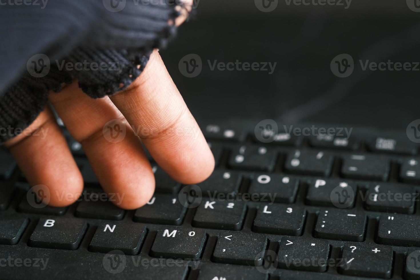 close up of hand stealing data from laptop top down photo