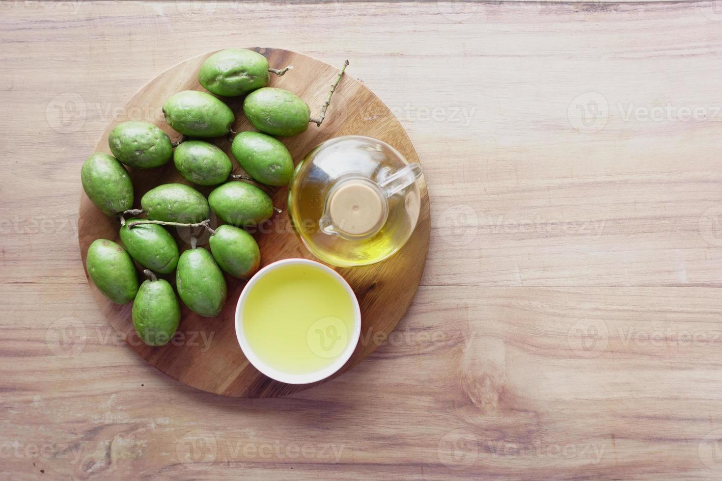 Botella de aceite de oliva y aceitunas frescas en la mesa foto