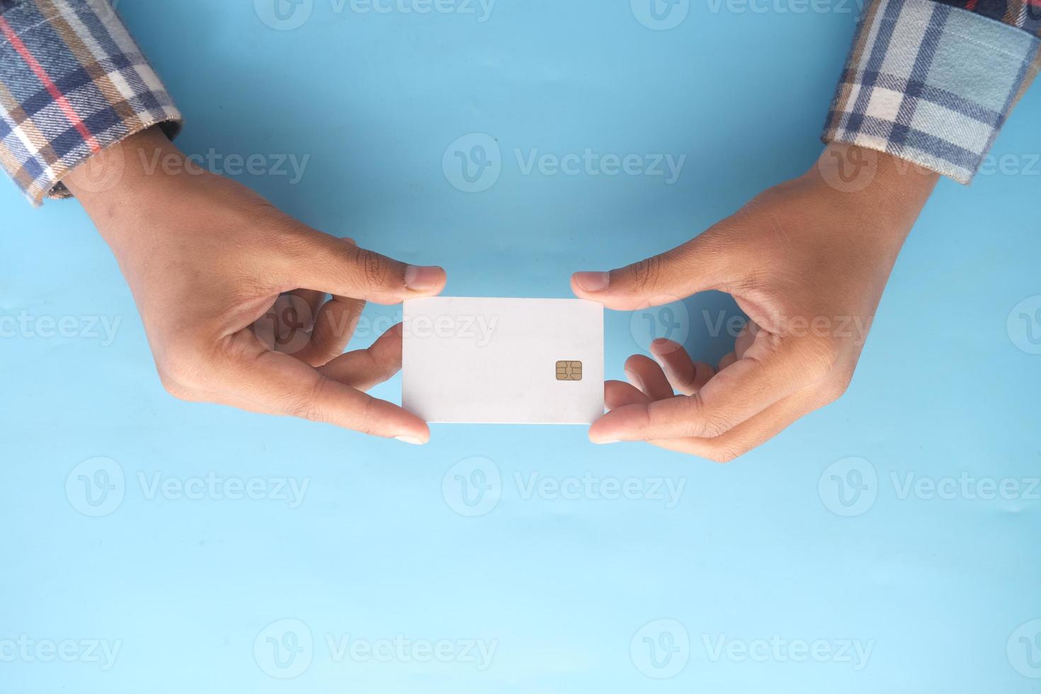 top view of hand hold a credit card on blue background photo