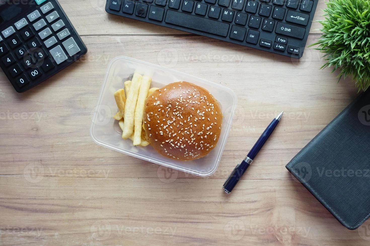 beef burger and french friend in a lunch box on office desk photo