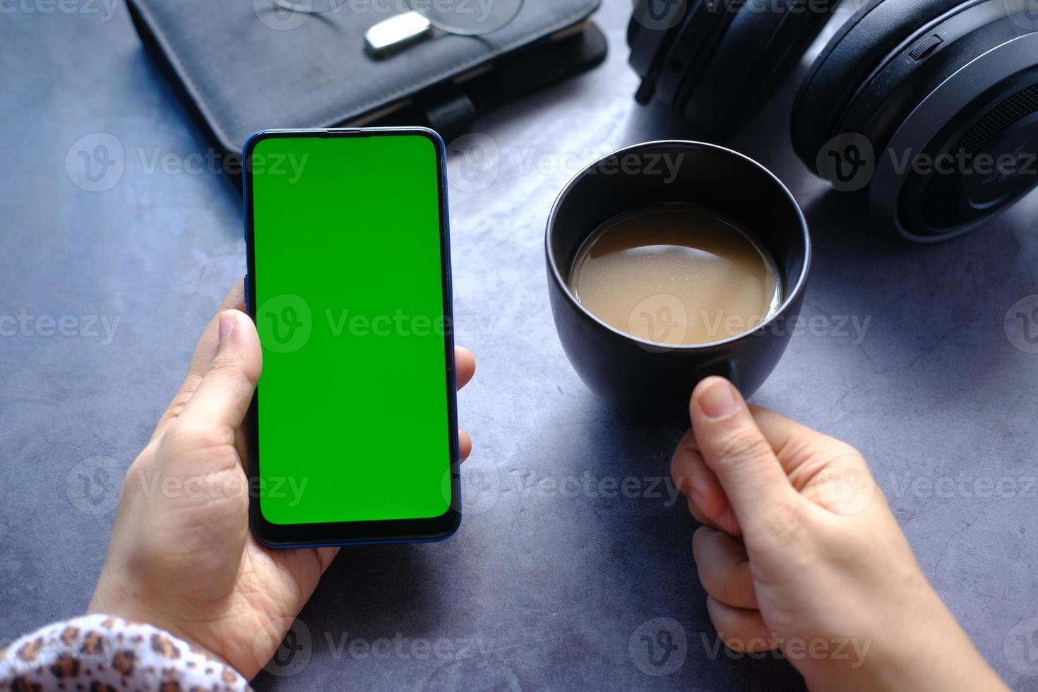 close up of women hand holding smart phone and coffee mug photo