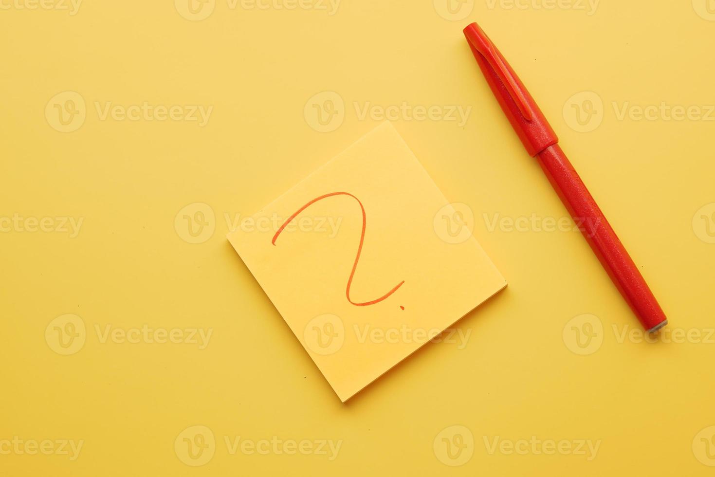 high angle view of question mark on paper on yellow background photo