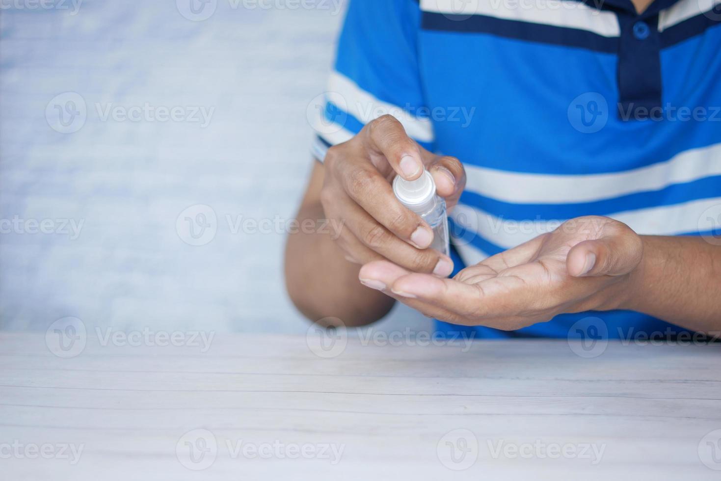 Cerca de la mano del hombre joven con spray desinfectante para manos. foto