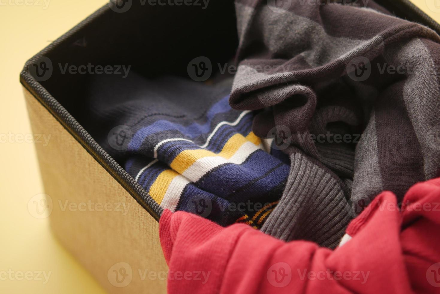 Donation box with donation clothes on a wooden table . photo