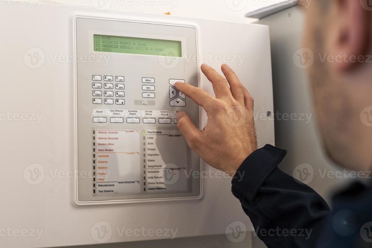 A male electrician setting up the alarm system photo