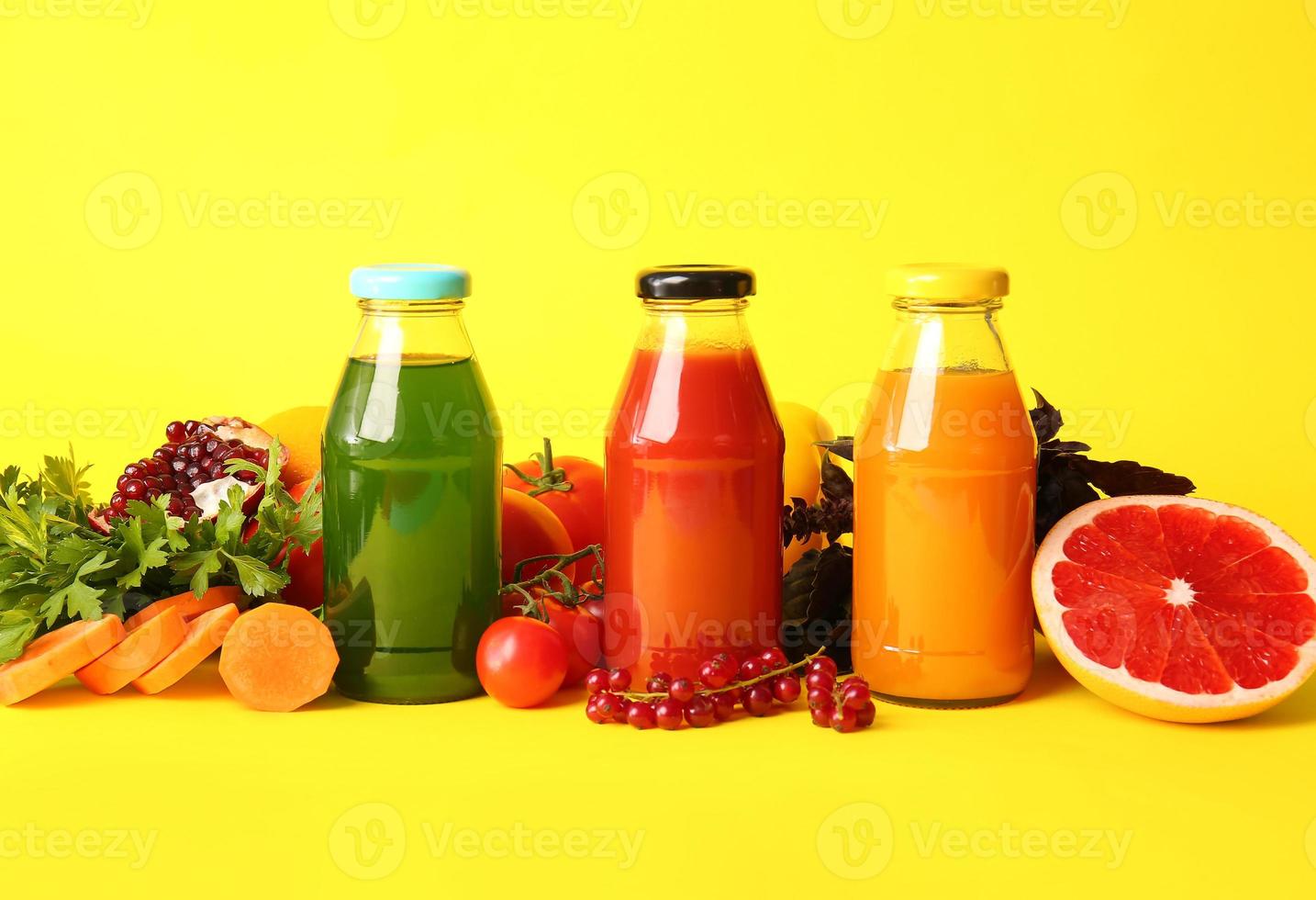 Bottles with healthy juice, fruits and vegetables on color background photo