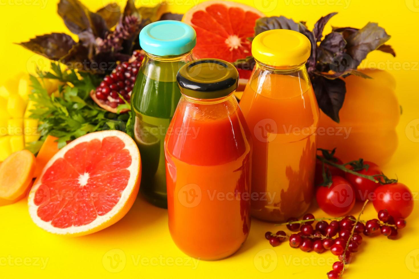 Botellas con jugos saludables, frutas y verduras sobre fondo de color foto