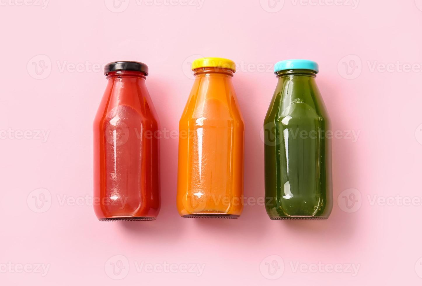 Bottles with healthy juice on color background photo