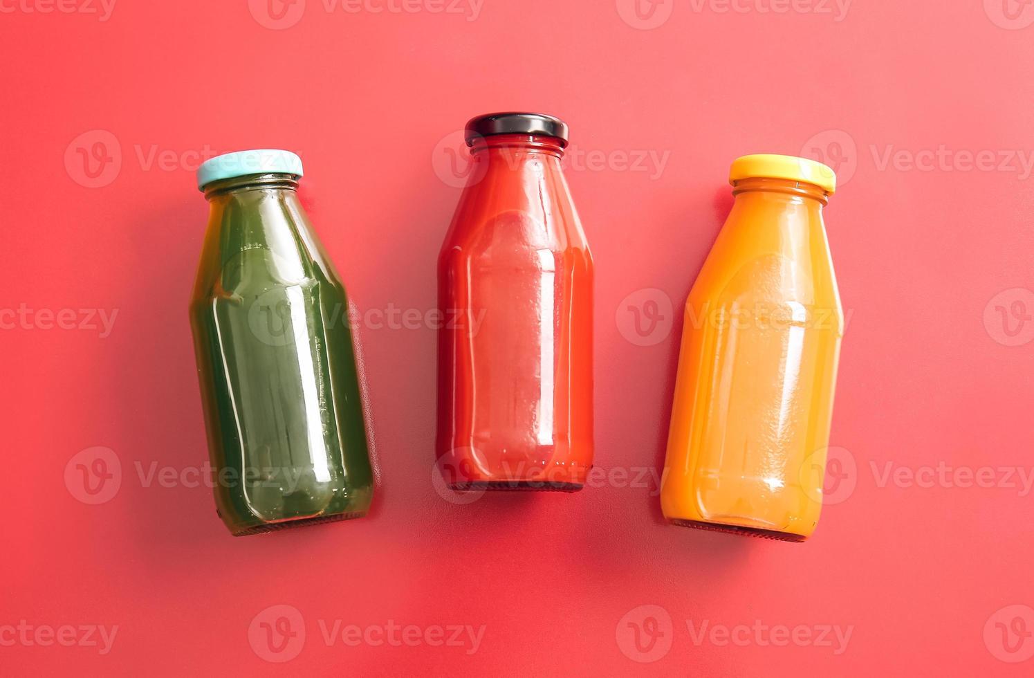 Bottles with healthy juice on color background photo