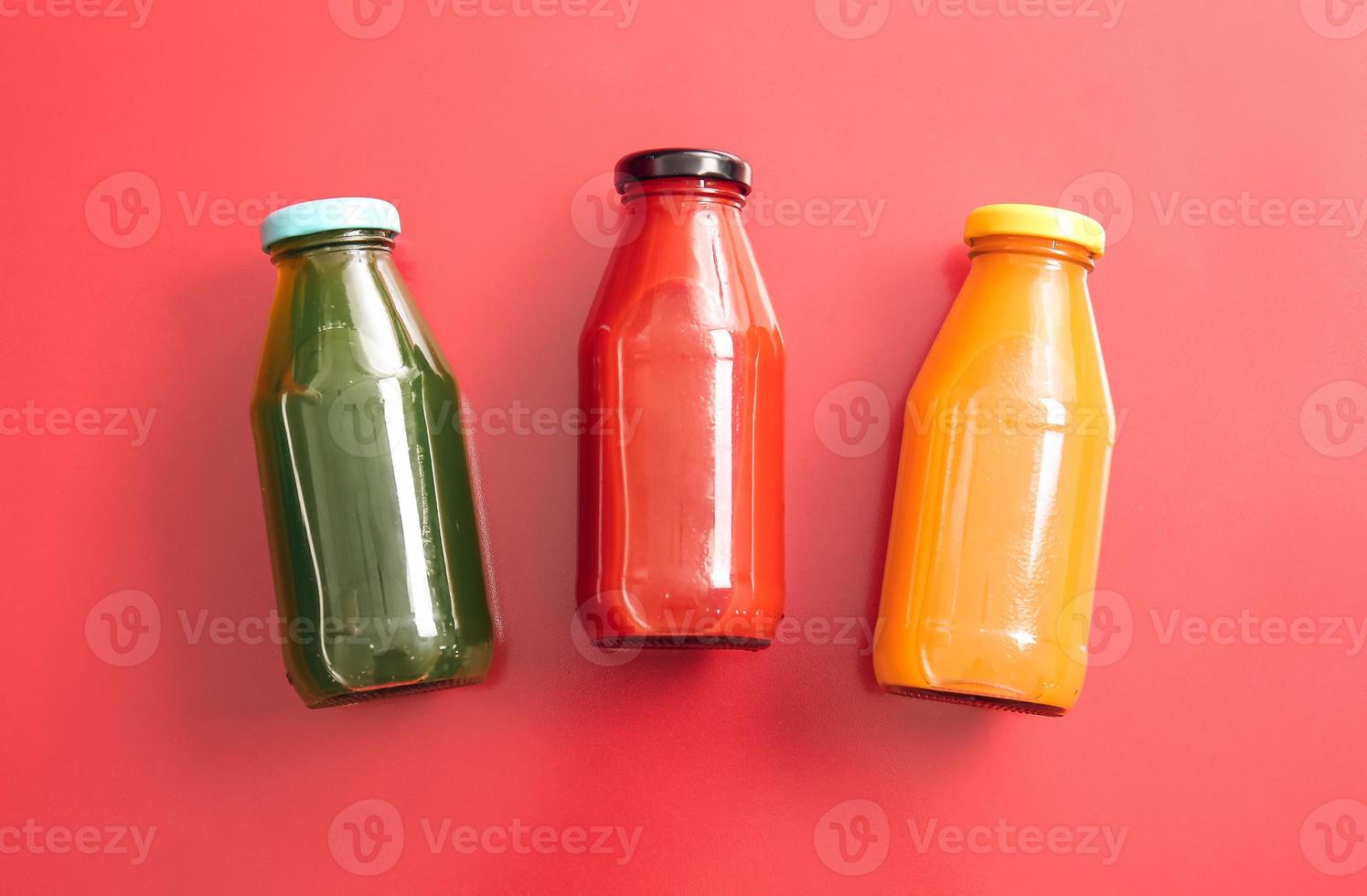 Botellas con jugo saludable sobre fondo de color foto