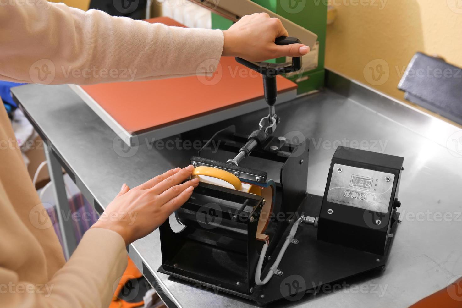 Young woman printing on cup at workshop photo