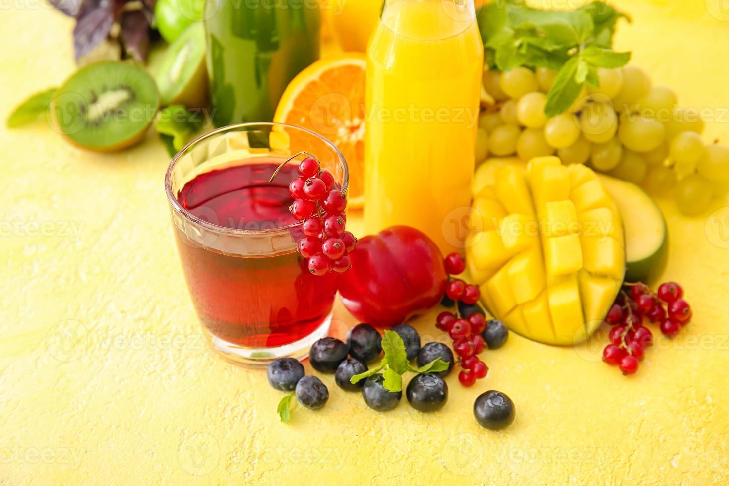 Glass with healthy juice, fruits and vegetables on color background photo