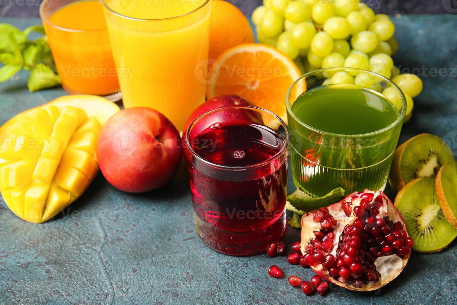 Glasses with healthy juice, fruits and vegetables on dark background photo