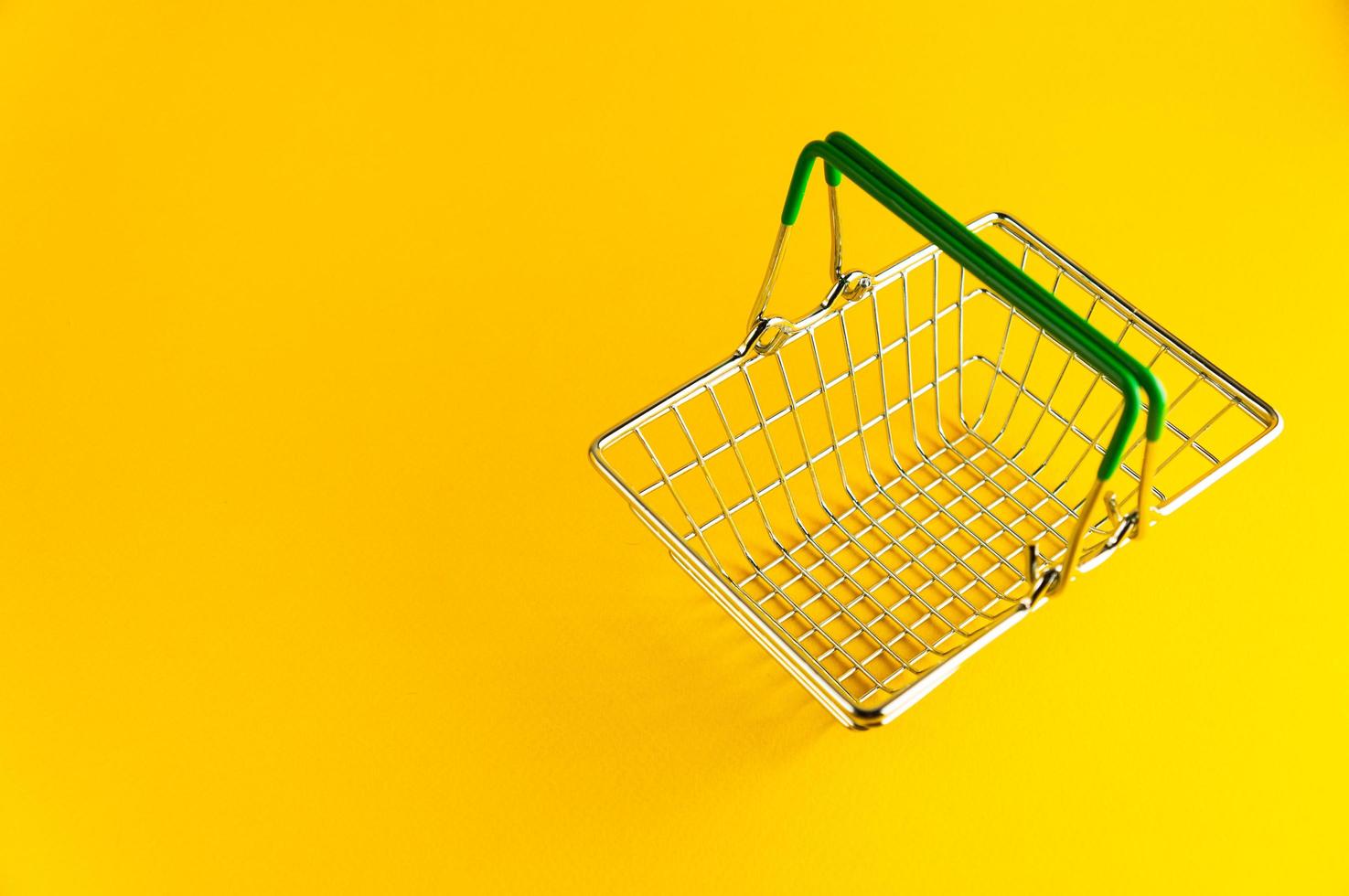 Shopping basket on a bright yellow background with an empty place for an inscription. photo